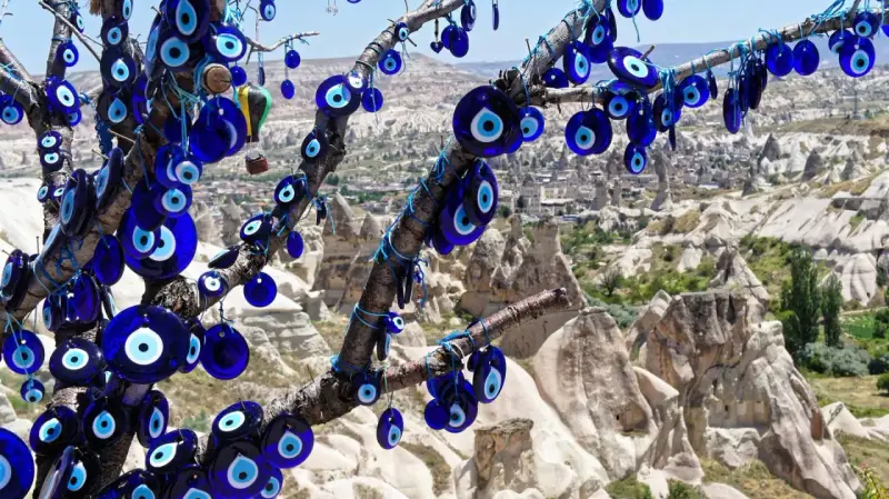 Ein Baum voller blauer Glasaugen, die wie ein arabisches Auge vor der Felslandschaft von Kappadokien schützen.